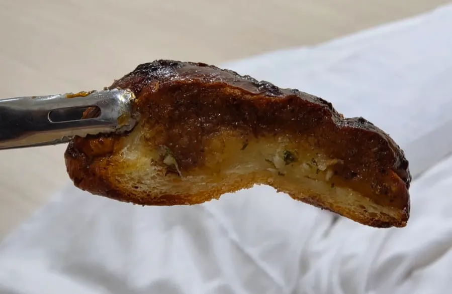 A piece of black garlic salt bread on a plate