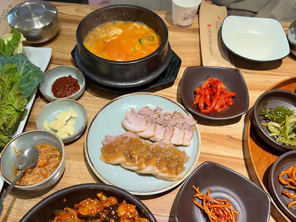 Ssambap table set with black garlic rice, wrap greens, and side dishes