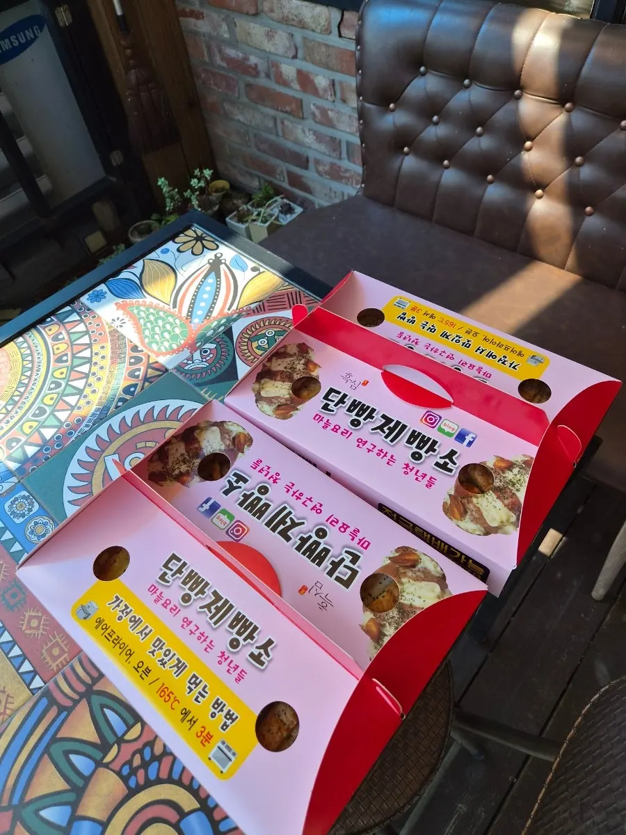 여행객 손에 들린 노란 마늘빵 선물 상자