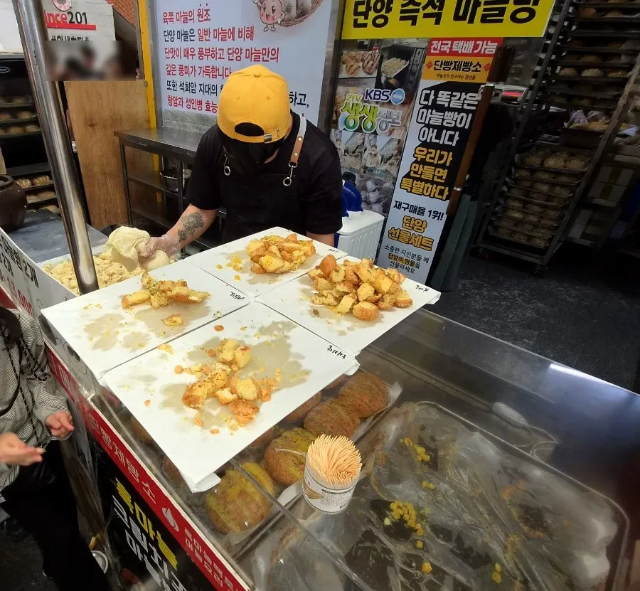 마늘빵을 굽고 소스를 바르는 매장 안쪽 작업 모습