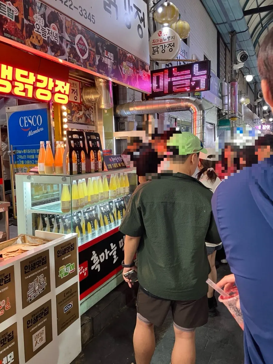 Market alley with a waiting line in front of the chicken shop
