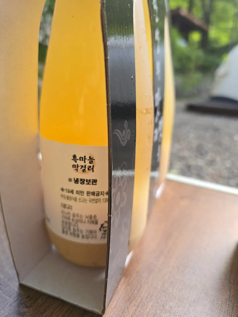 단양 마늘막걸리 병과 캠핑장 저녁 테이블