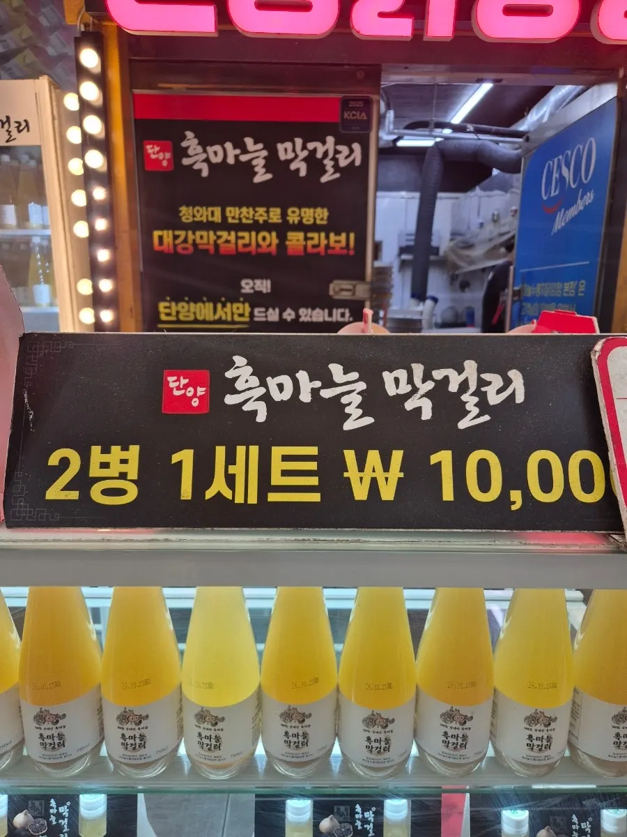Black garlic makgeolli displayed as gift items with menu information