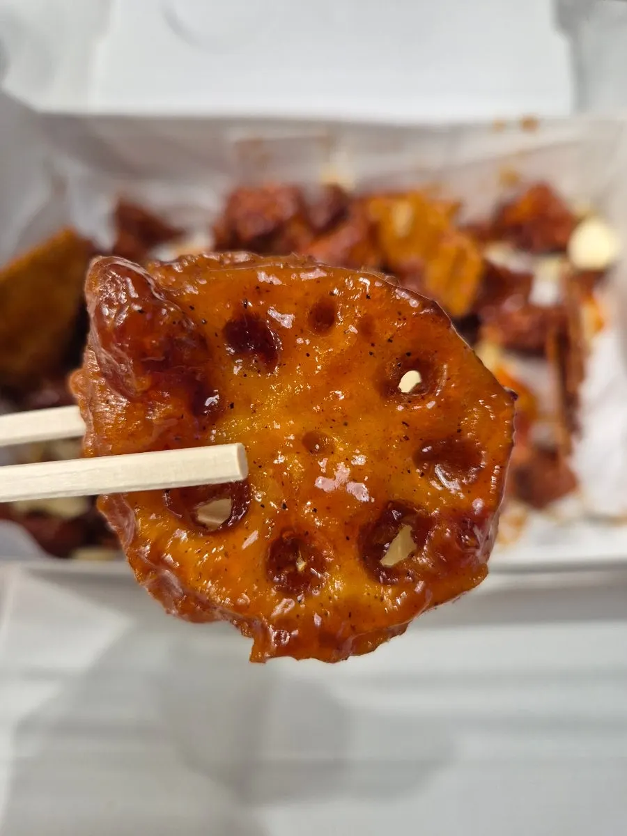 A piece of dakgangjeong picked up with chopsticks