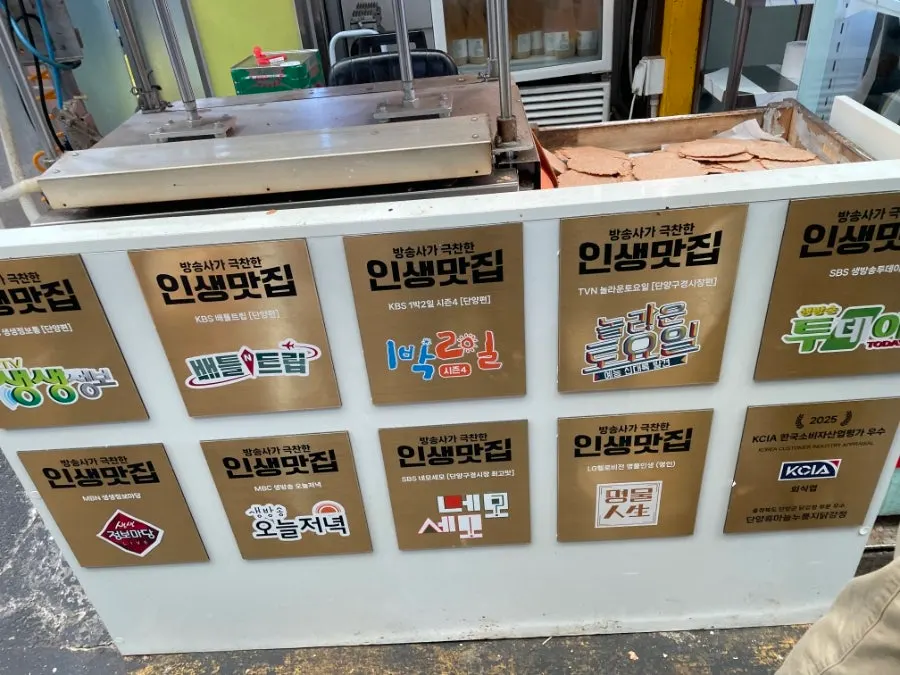 Storefront of the dakgangjeong shop with TV feature credits displayed