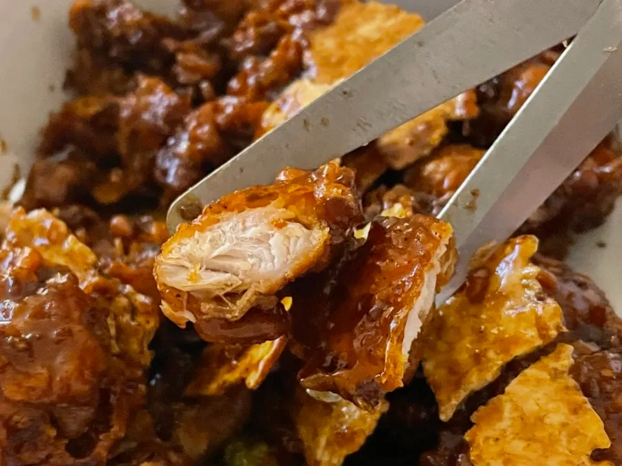 Thick pieces of chicken coated in thick black garlic sauce
