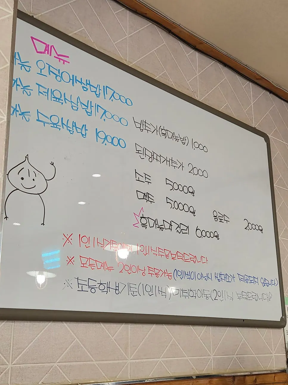 写有鱿鱼包饭、辣炒猪肉包饭、熟肉包饭的菜单牌