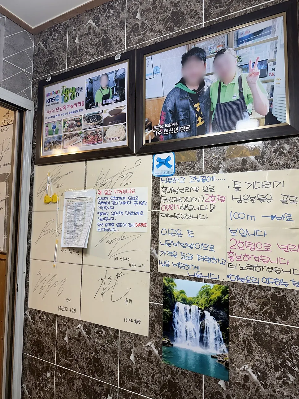 Visitor photos and signatures posted on the wall