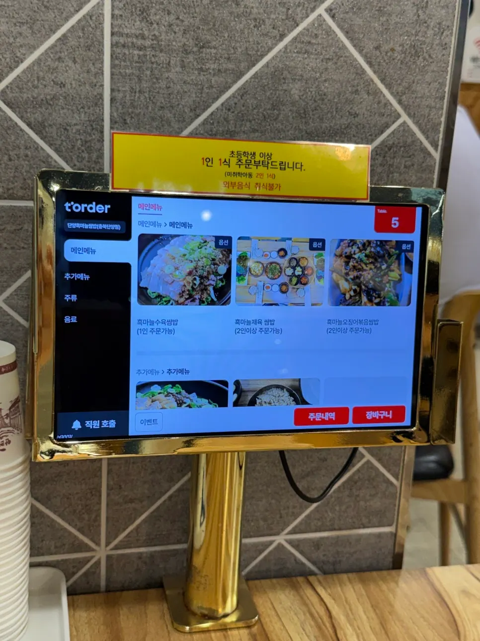 Tablet ordering screen at the table with party-size notices