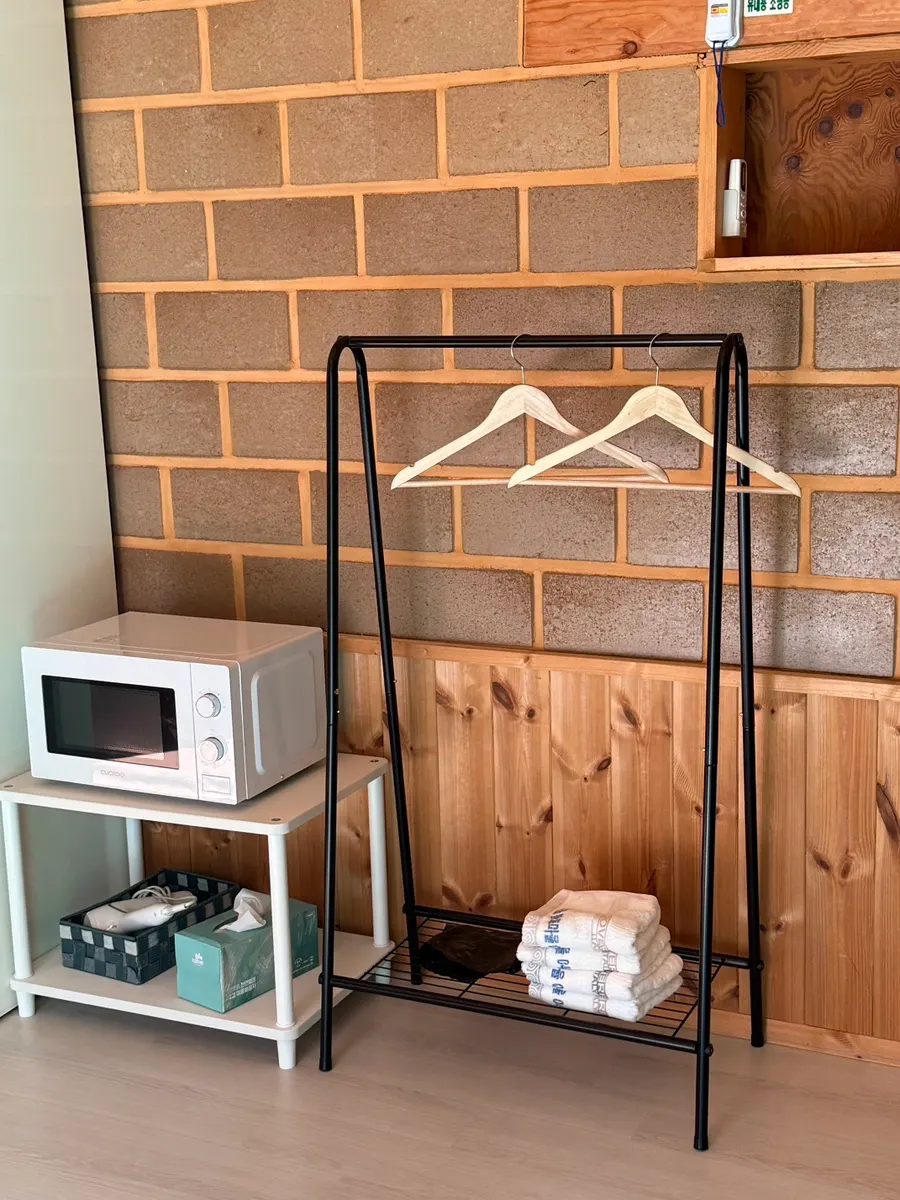 Hangers, hair dryer, and towels set up in the room