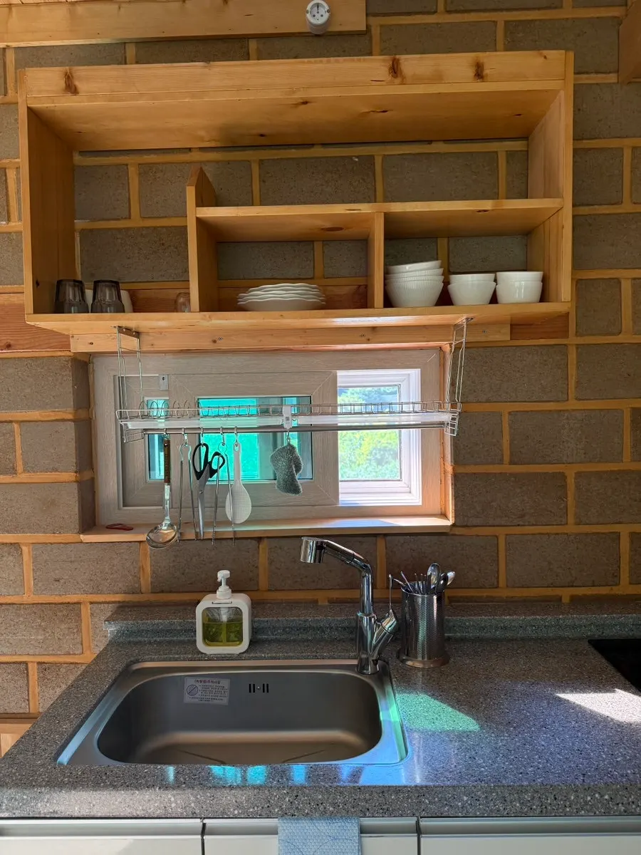 Pension room kitchen with induction stove and dishware
