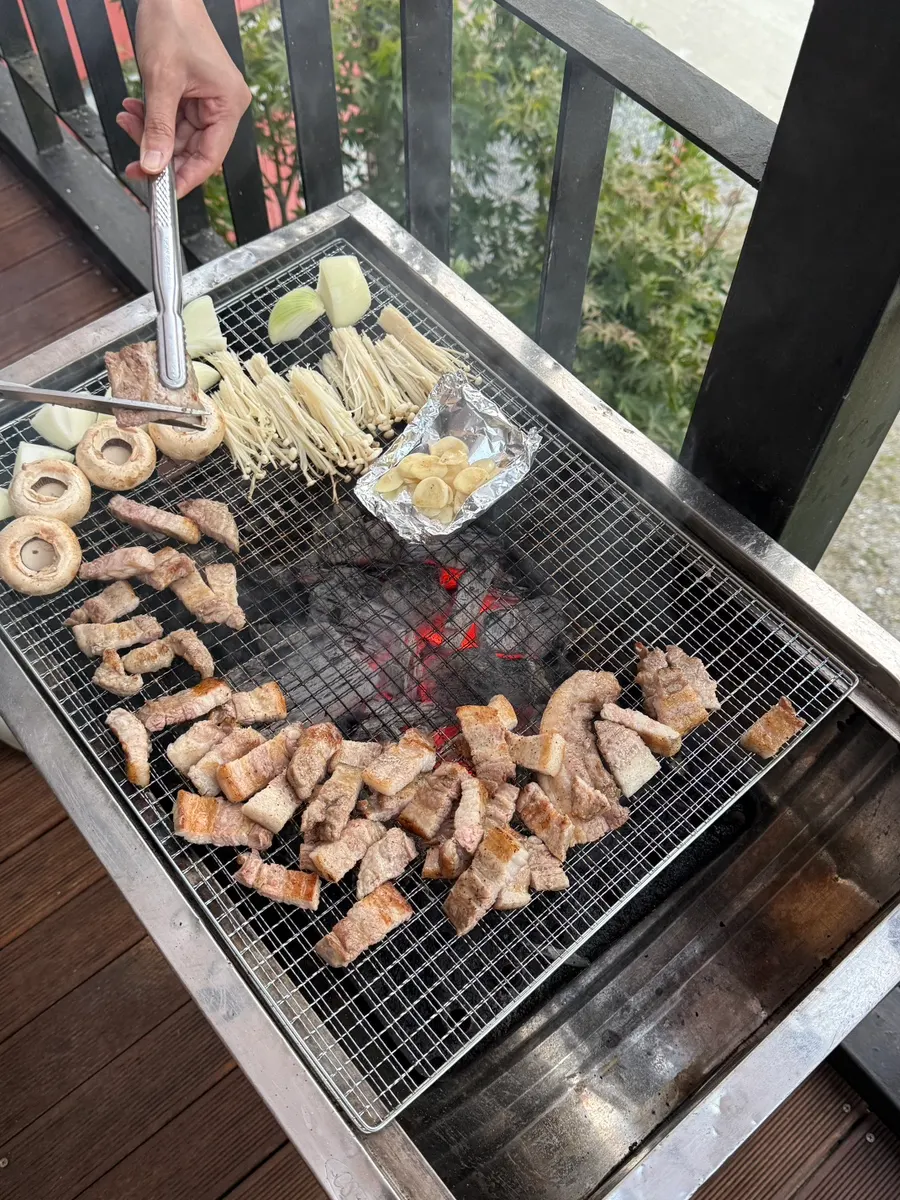 Grilling meat over charcoal on the veranda