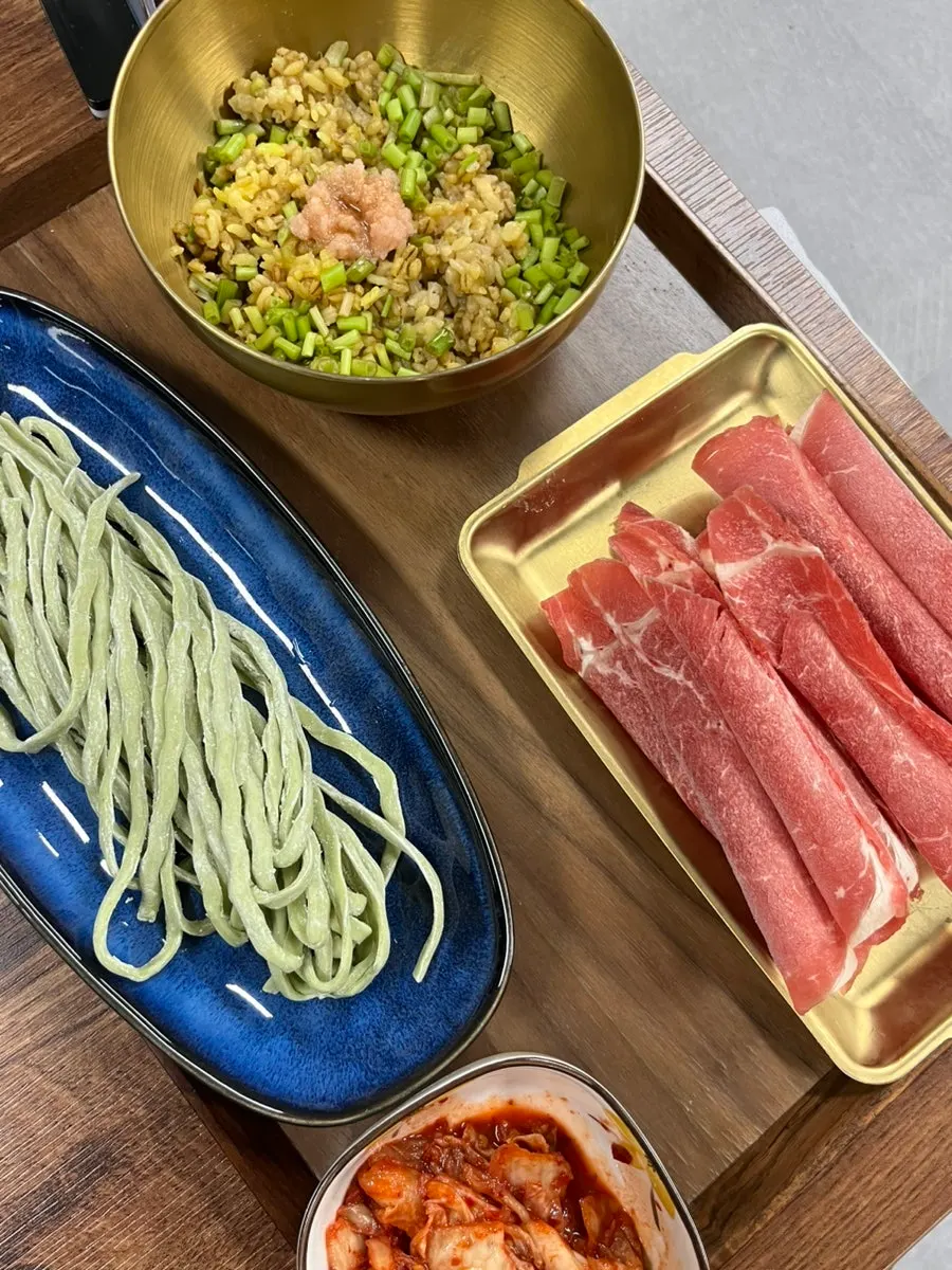 First course of kalguksu noodles, meat, and roe-turmeric rice