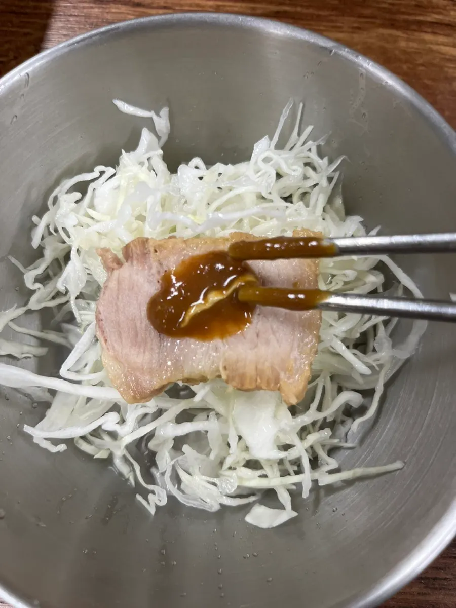 Topping the braised pork with cabbage before eating