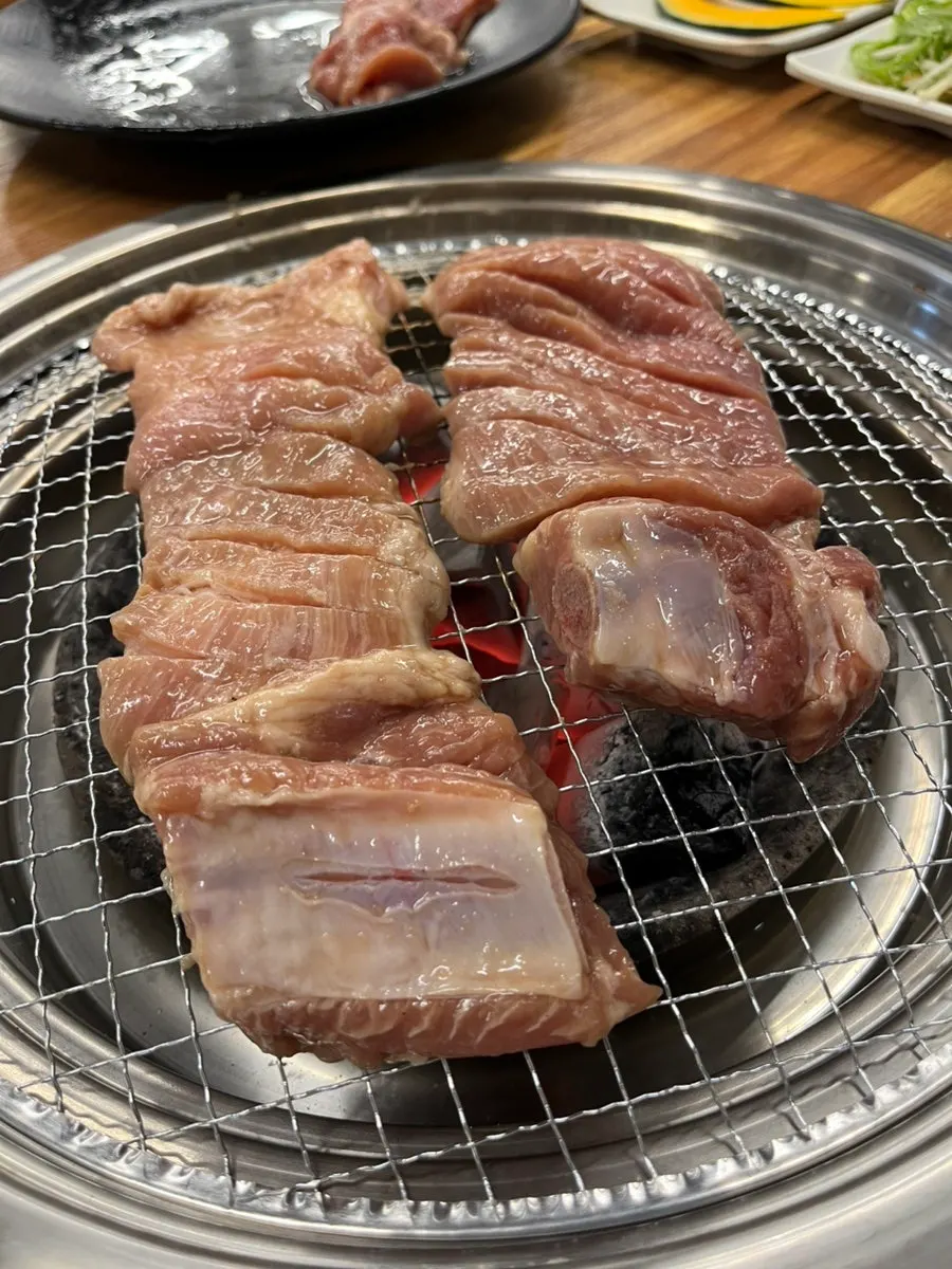 Thick marinated pork ribs on the grill with potato and sweet pumpkin