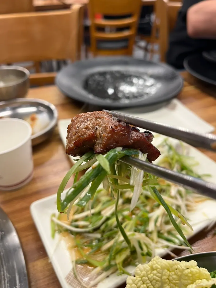 A piece of pork ribs placed on top of seafood doenjang rice
