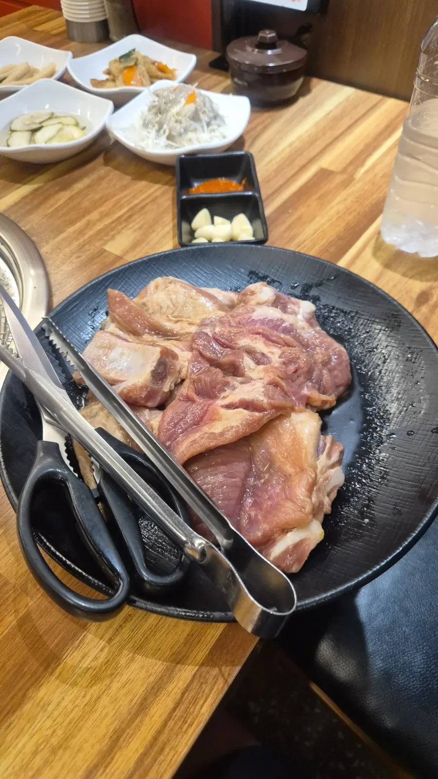 Marinated pork ribs placed on the charcoal grill at Dwaegal Gongmyeong Soba