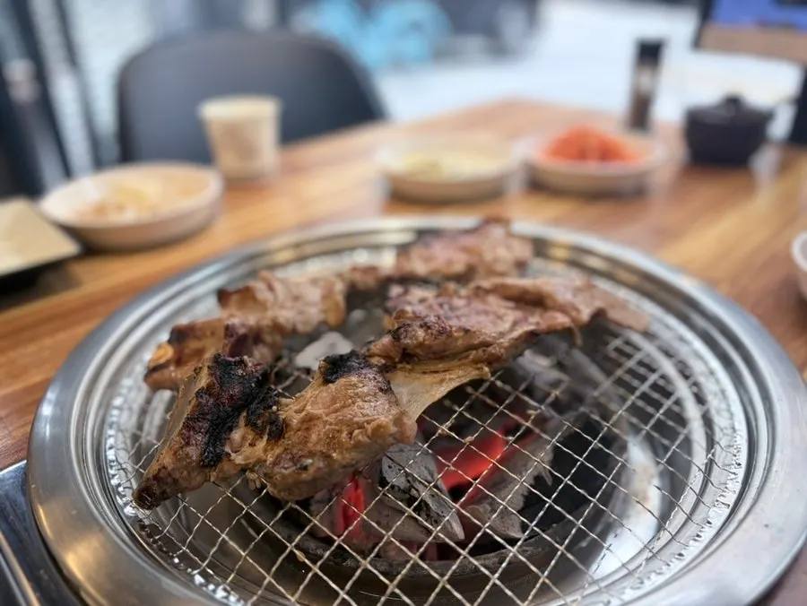 Pork belly and marinated pork ribs grilling over charcoal