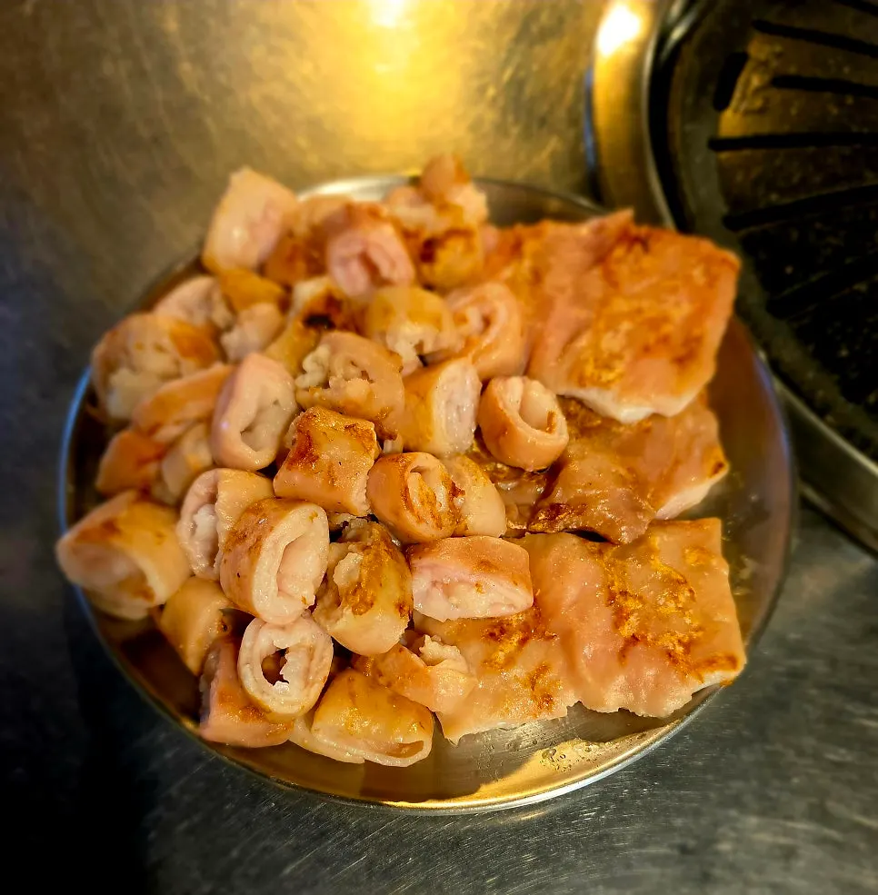 A plate of three servings of pre-grilled raw pork makchang