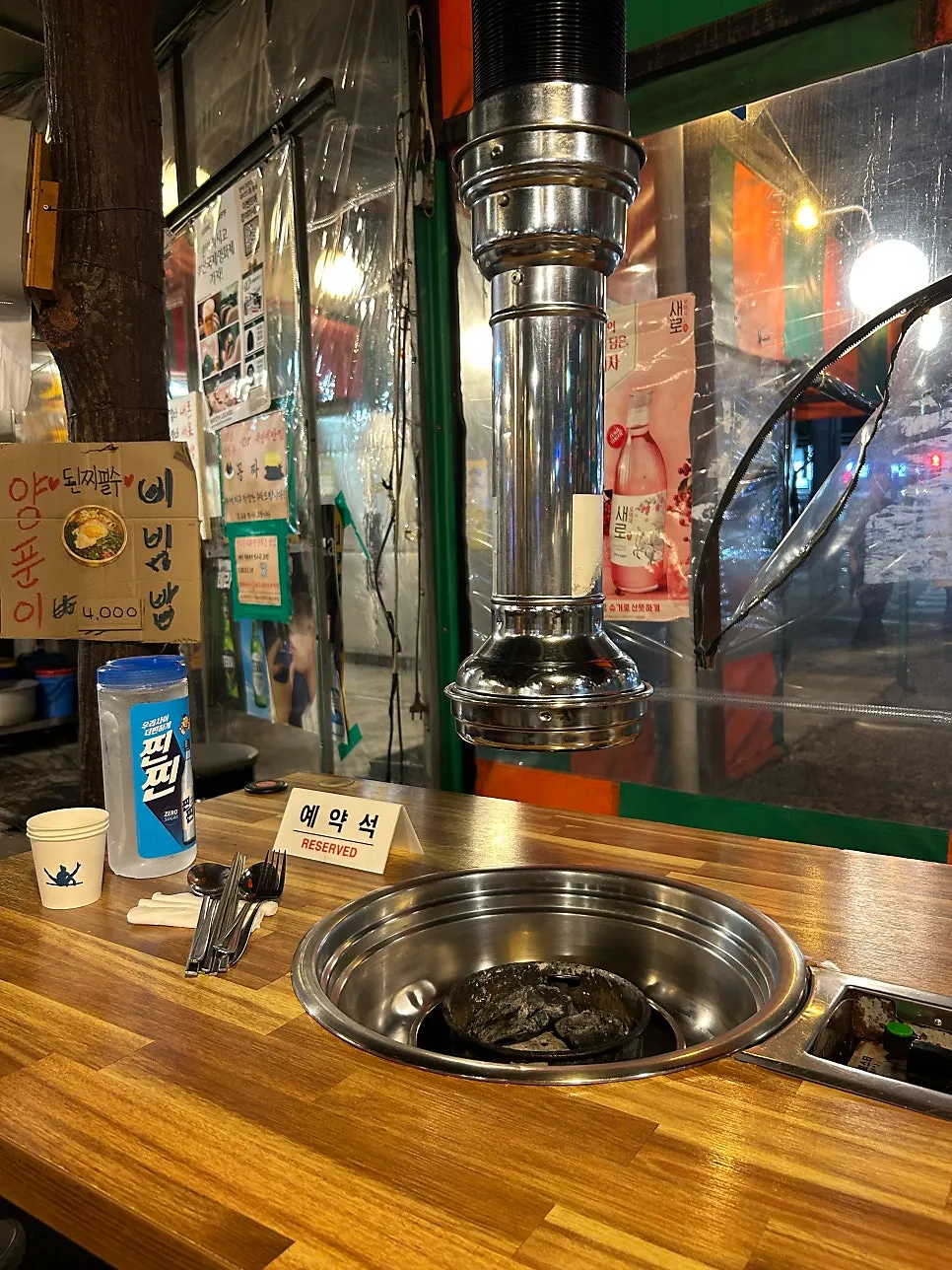 Drum-can table seating under the vinyl tent