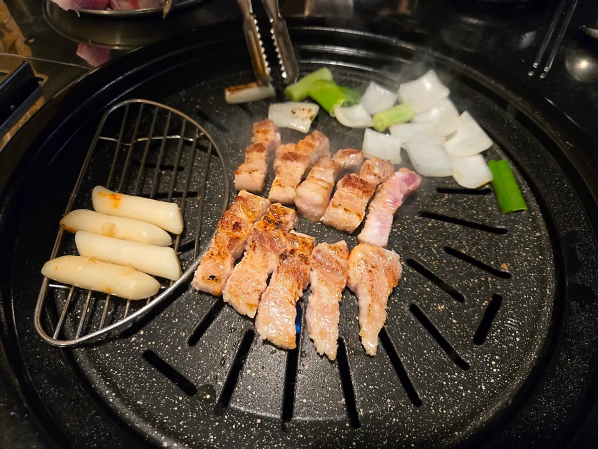 떡과 양파를 함께 올린 삼겹살 불판