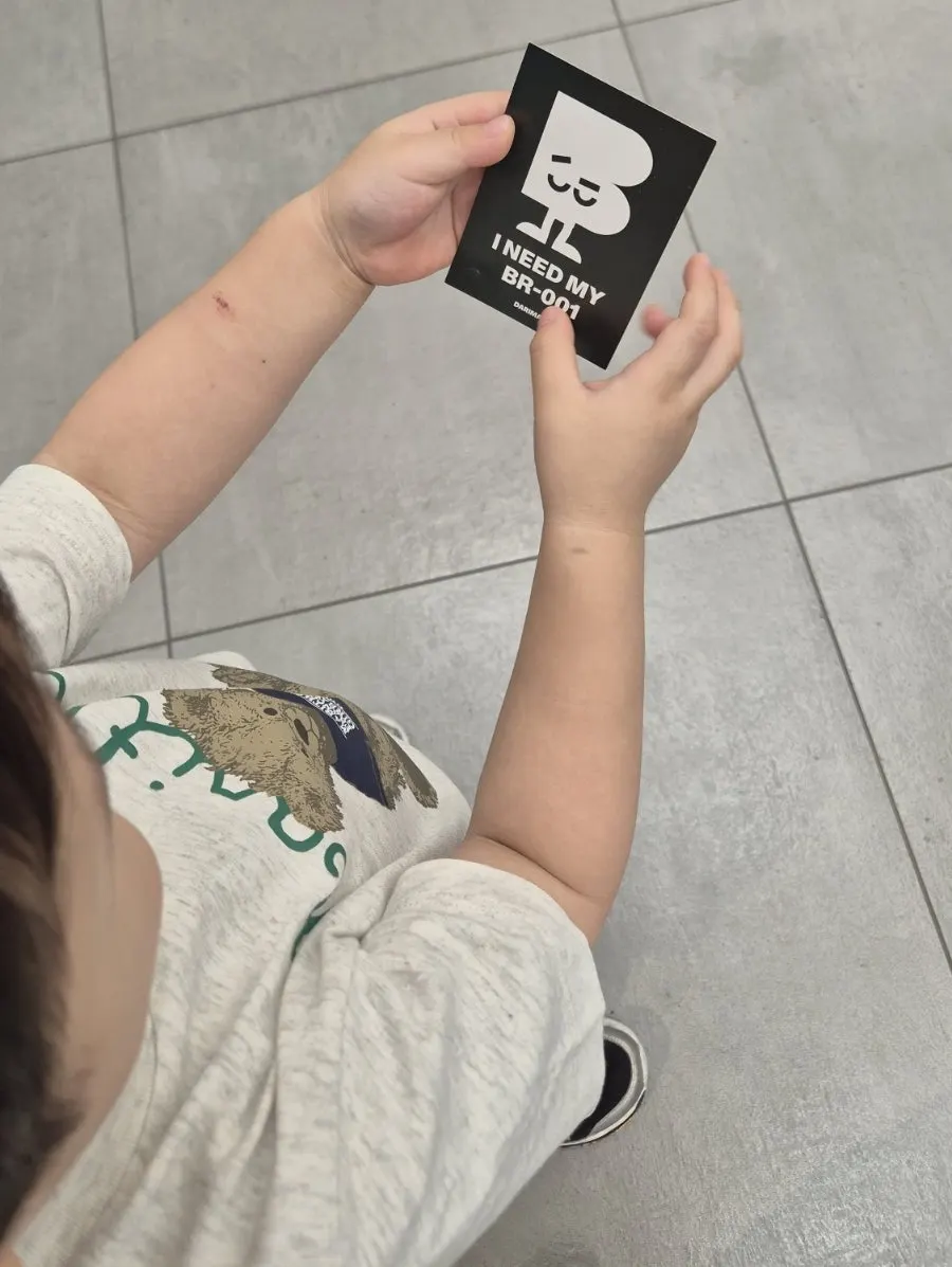 A child holding the gray signature logo box