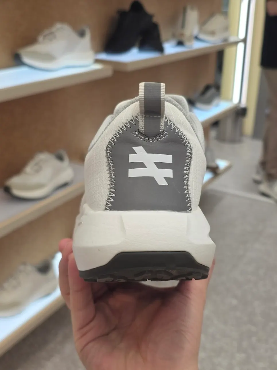 Visitor examining a HYROX shoe at the pop-up