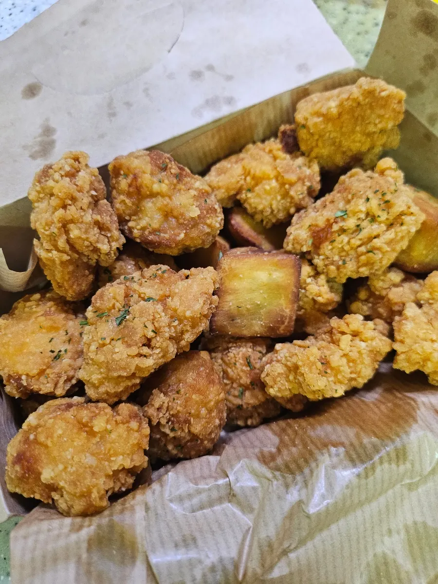 테이블에 펼친 치킨과 햄버거 포장 구성
