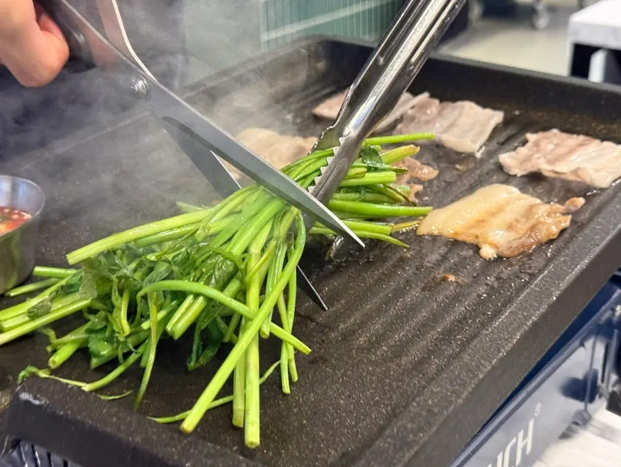 Thickly sliced 1+ grade frozen pork belly on the grill