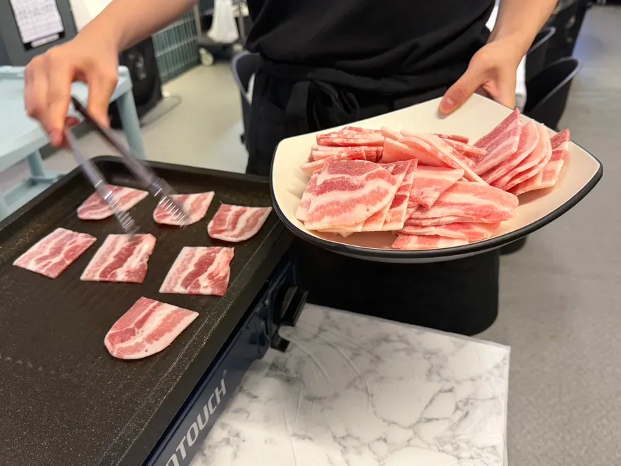 Three servings of frozen pork belly plated out