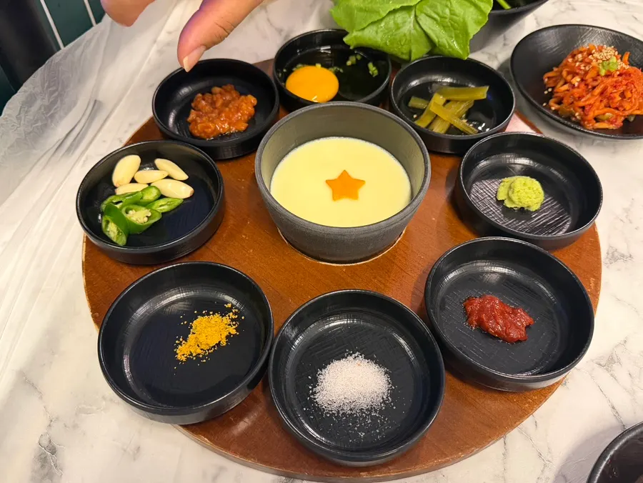 Full banchan spread with sauces, sides and steamed egg