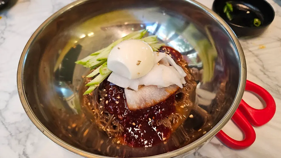 Bibim naengmyeon topped with egg and meat