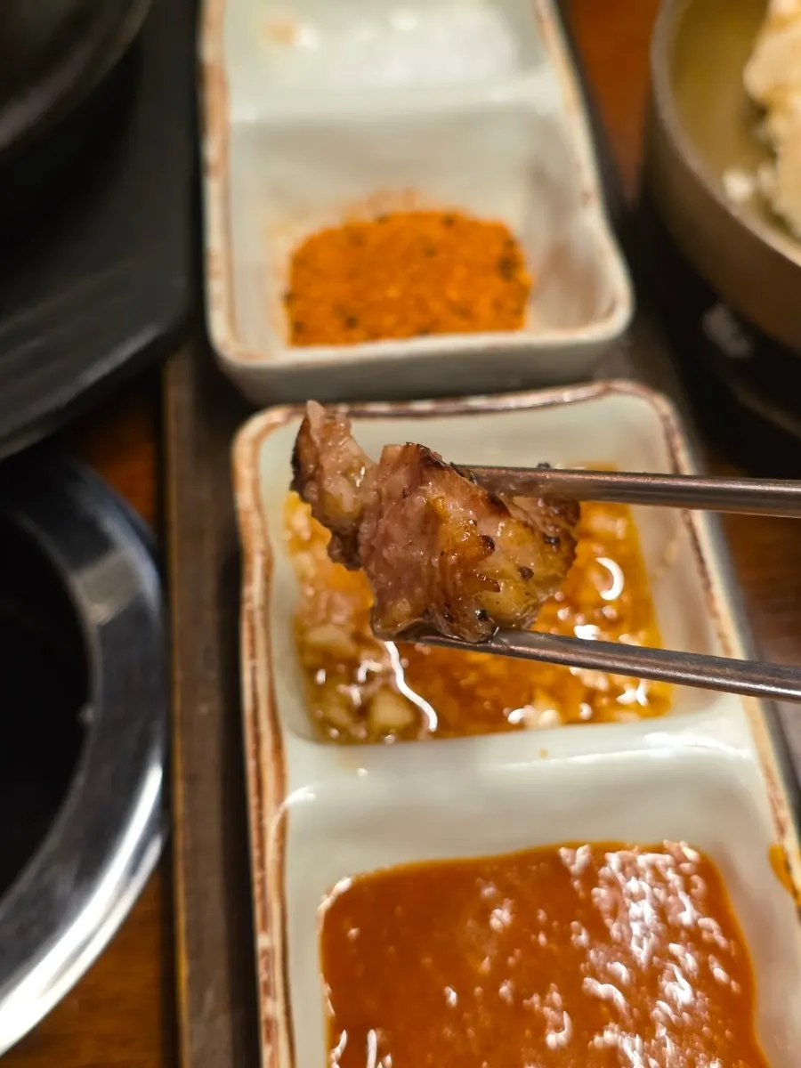 A piece of woodae galbi dipped in salt