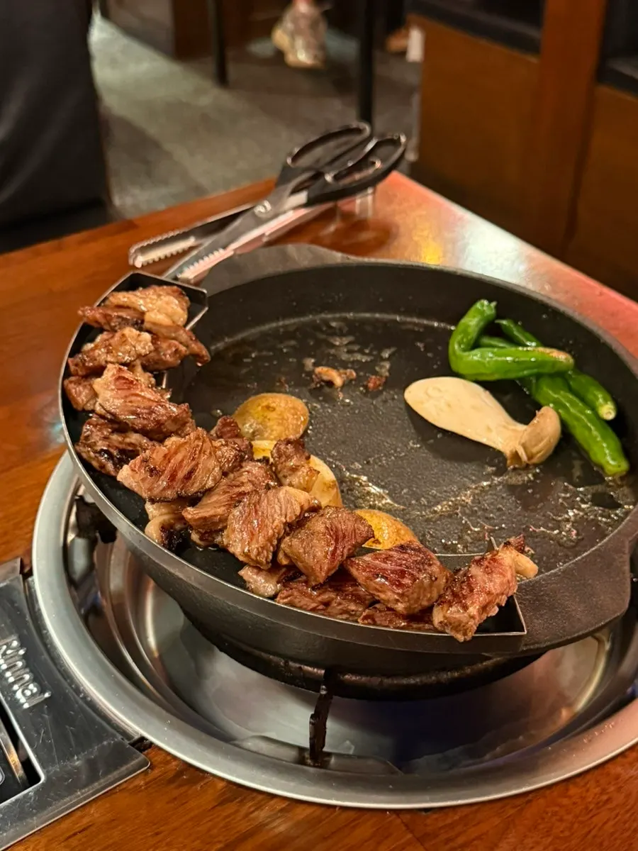 Woodae galbi cut into bite-sized pieces with side vegetables