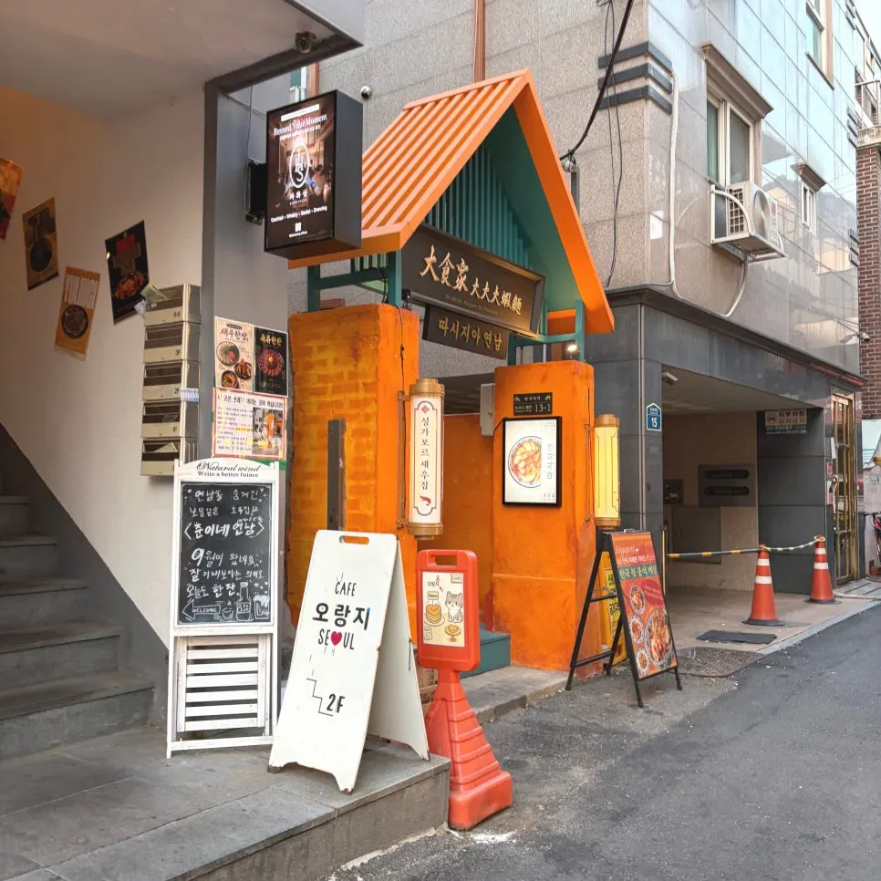 Exterior of Ttasijia Yeonnam with orange door in the alley