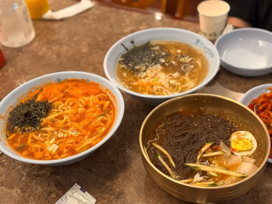 Full table with cham daseon kalguksu, jang kalguksu, naengmyeon, and yukjeon
