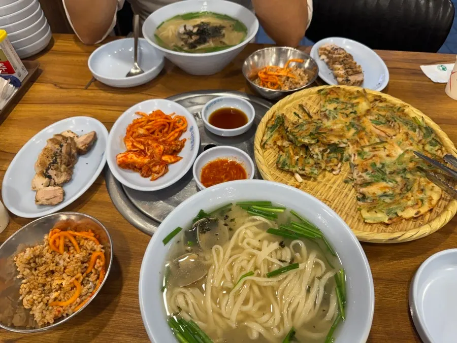 Table spread of kalguksu, seafood pancake, and boiled pork together