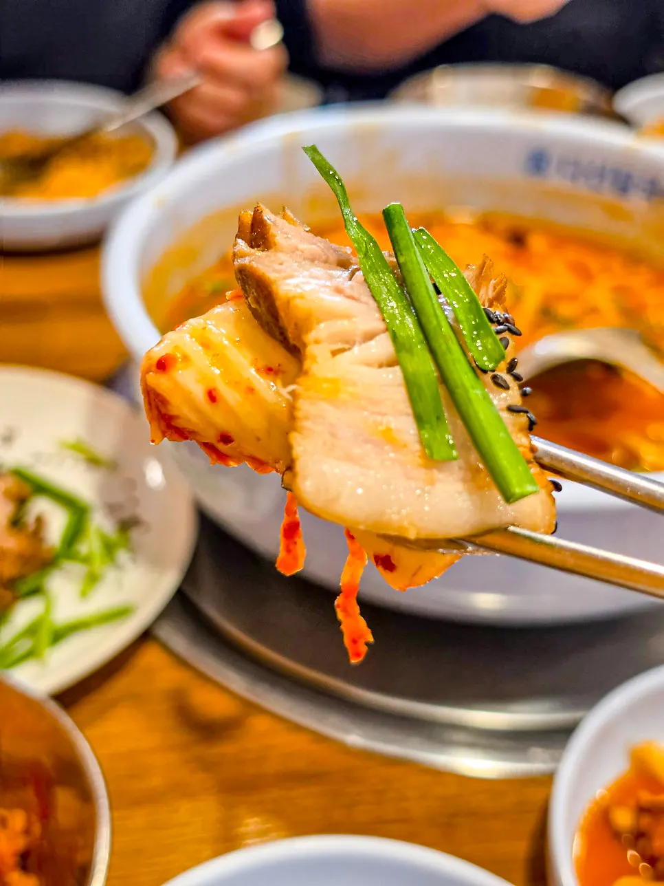 A bite of pork topped with geotjeori and chives