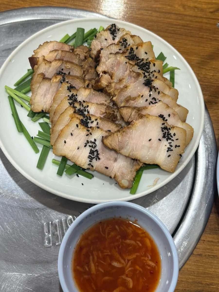 부추 위에 담긴 접시 수육 한상
