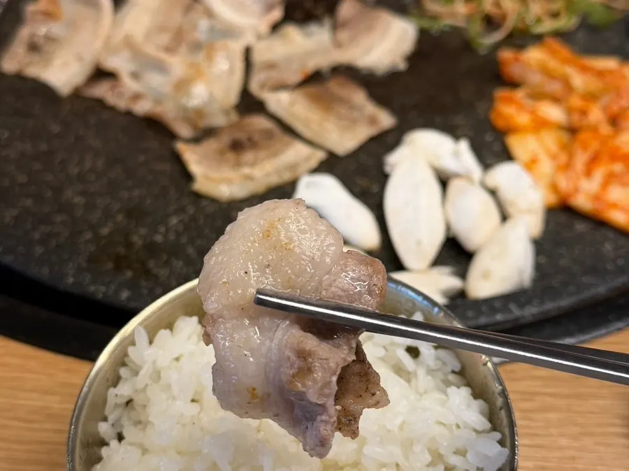 상추와 깻잎에 마늘을 올린 대패삼겹살 쌈