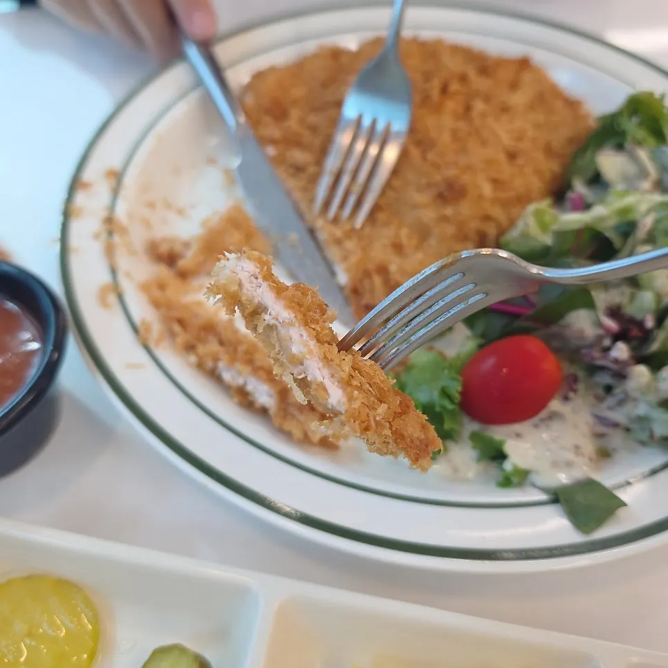 Dipping the whole grain salad pork cutlet bite by bite