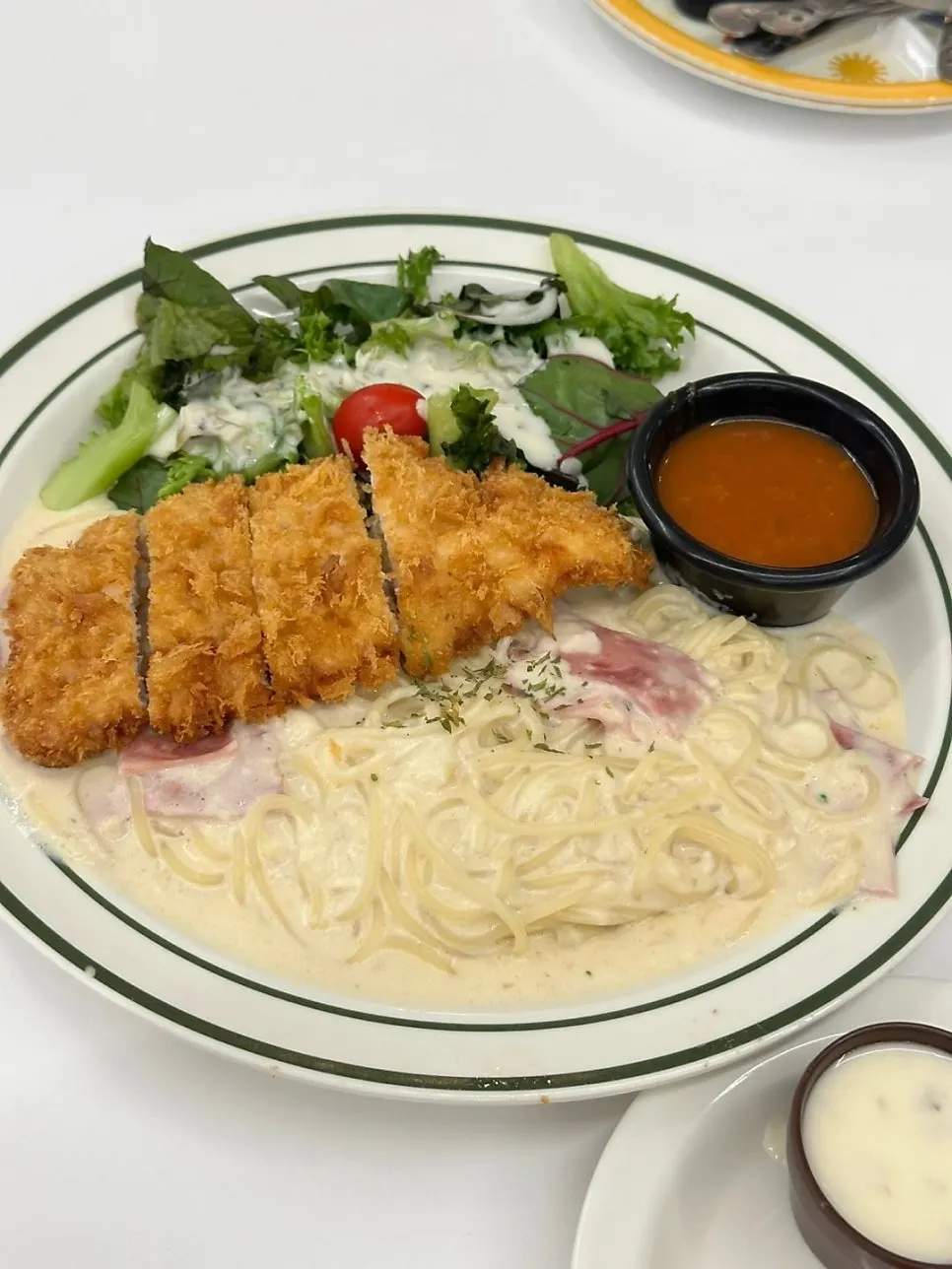 Bacon cream pasta topped with mini pork cutlet