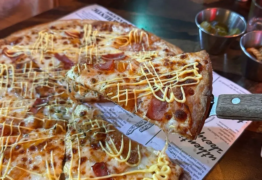 Close-up of thin-crust pizza studded with diced potato