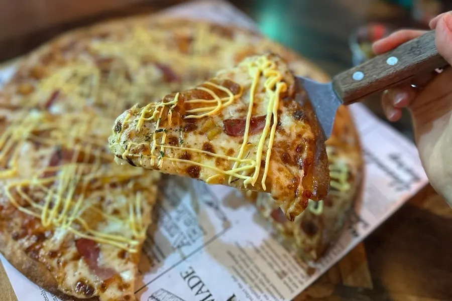 Pizza toppings covered in cheese and garlic sauce