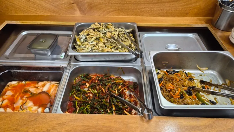 Self-serve corner with japchae and green onion kimchi