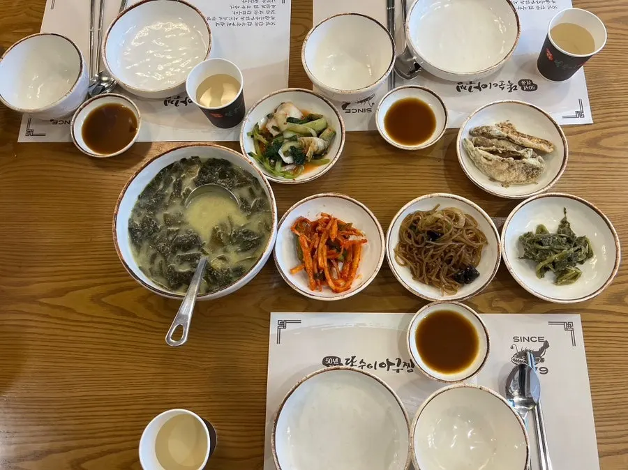 A spread of basic banchan including pollack seaweed soup and young radish kimchi