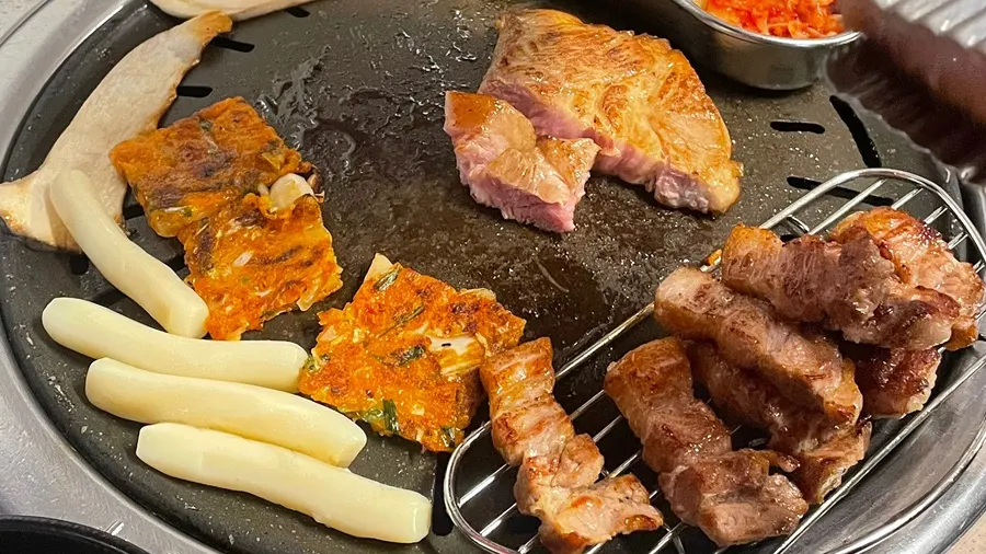 Ttukbang salted pork neck being grilled