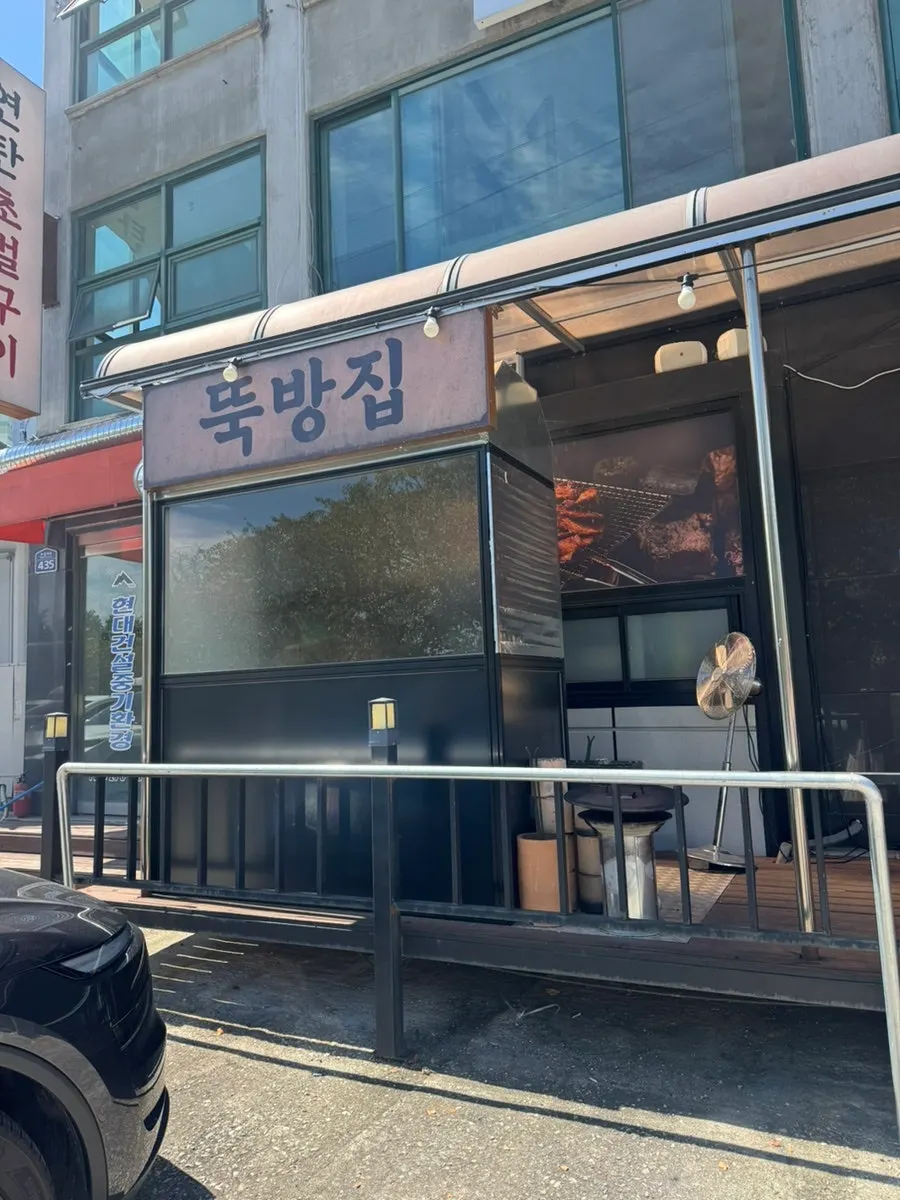 가게 밖 연탄불에서 고기를 굽는 모습