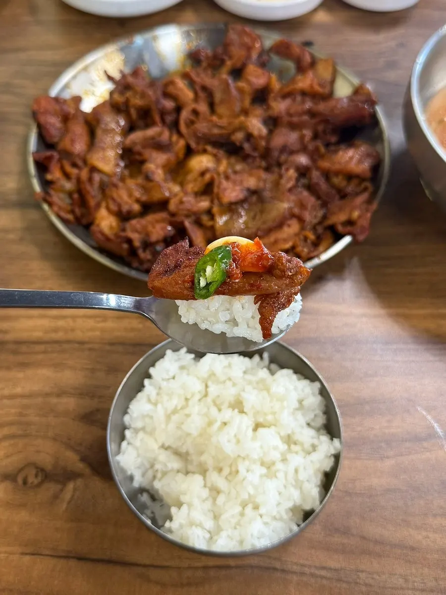 밥 위에 고추장구이와 고추, 마늘을 올린 한 술