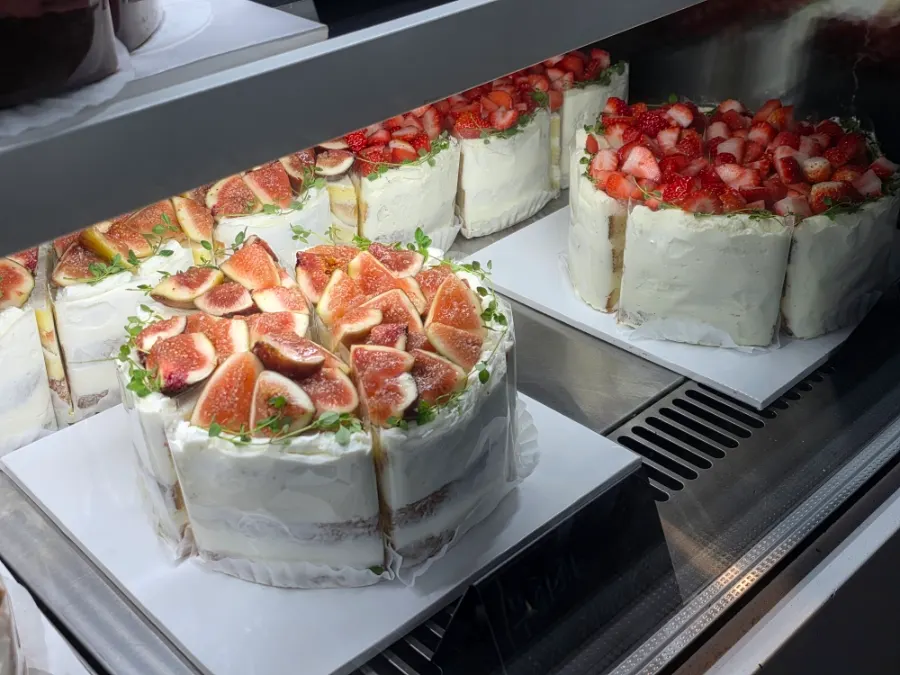 Cakes topped with seasonal fruit on display